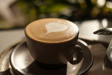 Photo of Cappuccino coffee close up in the making above wooden plate