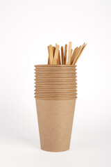 Disposable kraft paper cups and wooden coffee sticks on white background. Free space for your brand