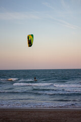 Windsurfing at sunset on a cullera beach. calm sea and vivid colors in the sky