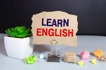 Learn english - note at blue and yellow background with teachers glasses