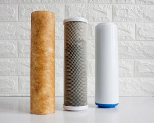 Used cartridges for water purification. Three cartridges for a household reverse osmosis system for water purification from mechanical impurities, chlorine and inorganic impurities.