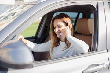 Young woman talking on cellphone while sitting in the car.