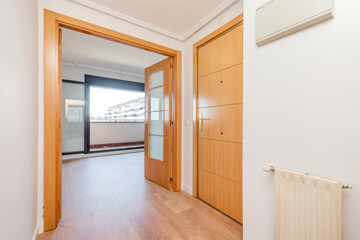 Hall of a family house with doors to a living room with access to the terrace in an empty apartment