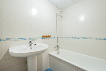 Toilet with white sink and bathtub and blue porcelain border in a vacation rental apartment