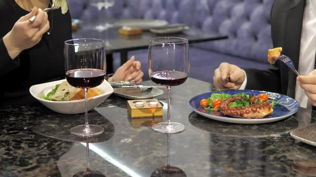 An elegant couple on a date in an elite restaurant on a romantic date. A man in a business suit is having dinner with a beautiful girl in an evening dress. The couple dines on delicious dishes