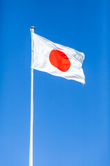 a japan's national flag fluttering in the blue sky on the autumn national holiday