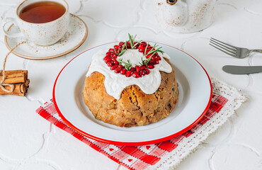 Traditional Christmas fruit pudding on white festive background.