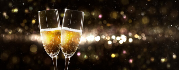 Fototapeta celebrating new year 2022 with 2 glasses of champagne on beautiful unfocused background obraz