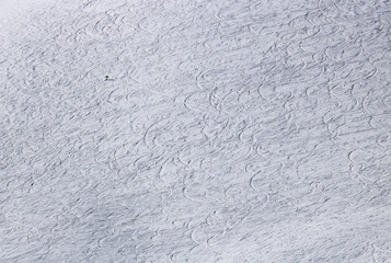 piste de ski avec nombreuses traces de ski mais vide avec un seul skieur