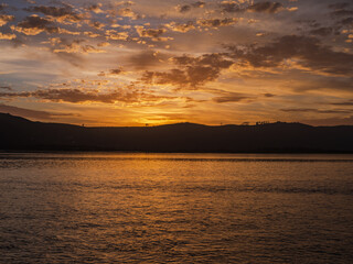 Golden sunset with dramatic sky clouds over Knysna lagoon