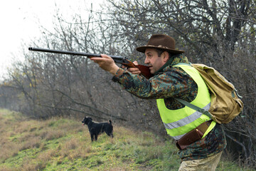 Hunter man in camouflage with a gun during the hunt in search of wild birds or game. Autumn hunting...