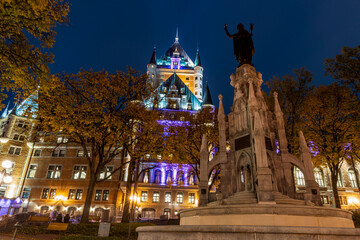 Fototapeta na wymiar Night view of the Quebec City Old Town in autumn. Place d'Armes, landscaped plaza with a fountain.