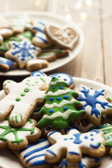 Homemade gingerbread cookies painted with colorful glaze surrounded by New Year's accessories. Christmas Baby Cookies