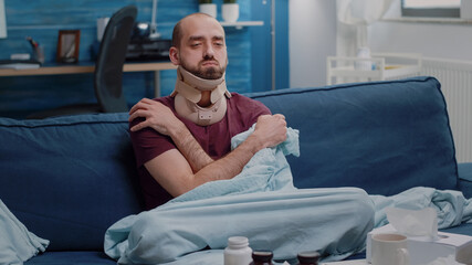 Unwell adult with cervical collar healing muscle injury and shivering because of cold and flu....
