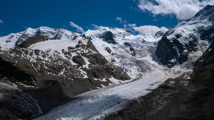 Morteratsch Glacier with snowy mountains in the Engadin in the Swiss Alps in summer with blue sky and sun.
