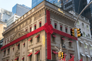 New York City, New York - December 2019: 2019 installation of the Cartier flagship store on Fifth Avenue with the gigantic bow and jaguars climbing the sides.  - obrazy, fototapety, plakaty