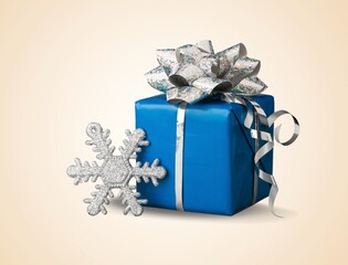 Christmas gift box with ribbon bow and shiny ornaments.