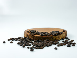Coffee beans scattered on a round wooden plank isolated on a white background. Product placement...