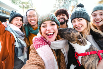 Happy millenial friends taking selfie portrait outside - Group of young people having fun walking...