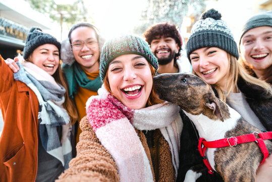 Happy millenial friends taking selfie portrait outside - Group of young people having fun walking on city street enjoying winter sunny day - Happy lifestyle concept - Backlight and bright filter