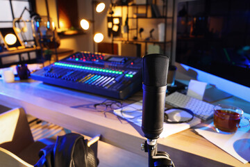 Microphone near table with professional mixing console in radio studio