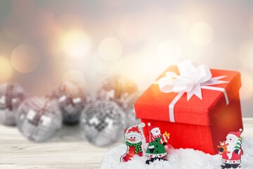 Banner. Christmas red gift box in a red snowy landscape on a bokeh background. Space for text. The concept of the delivery of gifts and greetings card happy New year. Close up.