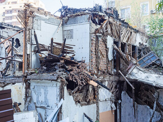 Old dilapidated building with tattered walls and a lot of trash outdoors