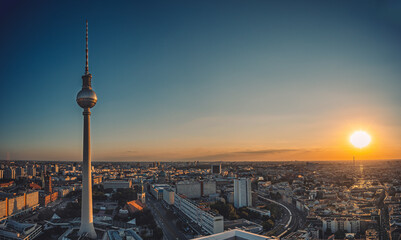 Scenic shot of the tv tower in berlin rising above all buildings with a sunset background
