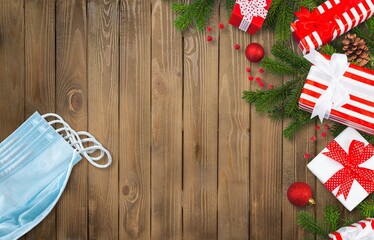 Christmas during COVID 19 pandemic concept with decorations, face masks over wood background.