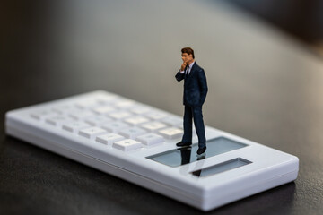 電卓とビジネスマンの人形