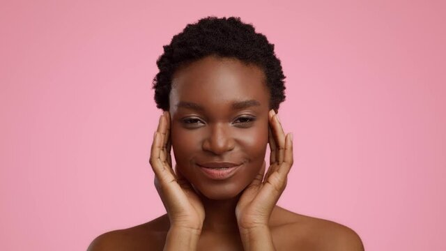 Relaxed African American Woman Massaging Temples Over Pink Background