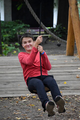 Young attractive guy goes down the zipline and smiles