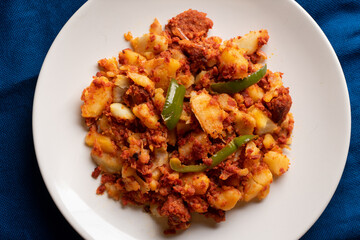Potatoes with chorizo on a blue background.  Mexican food