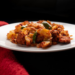 Potatoes with chorizo on a dark background.  Mexican food