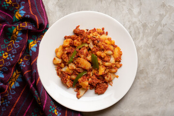 Potatoes with chorizo on a gray background.  Mexican food