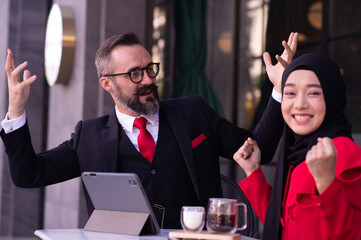 Businessman caucasian and business woman Muslim discussing, consulting, exchanging ideas, analyzing, considering, reasoning about work.