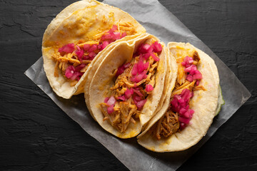 Pork meat tacos called cochinita pibil on a dark background. Mexican food