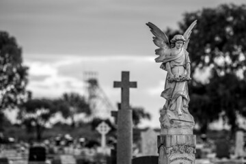 Grayscale shot of an angel statue in a cemetery