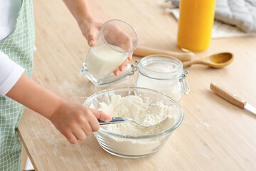 Teenage girl preparing dough in kitchen, closeup