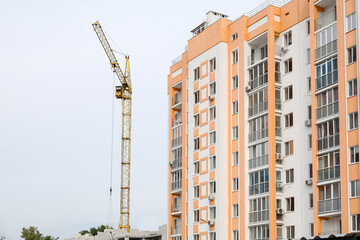 Fototapeta na wymiar View of modern bright building and construction crane in city