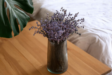 Vase with beautiful lavender flowers in bedroom