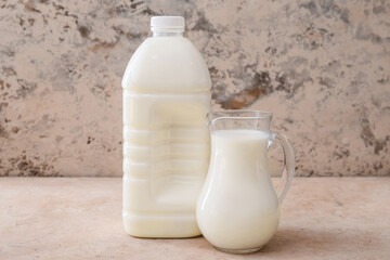 Gallon bottle and jug of milk on table