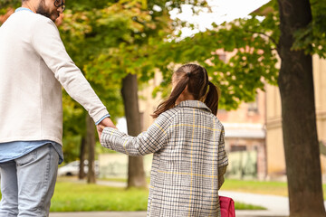 Obraz premium Man walking his little daughter to school