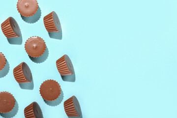 Tasty peanut butter cups on color background