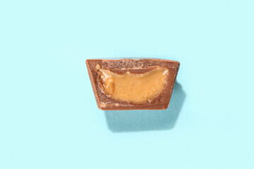 Tasty peanut butter cup on color background