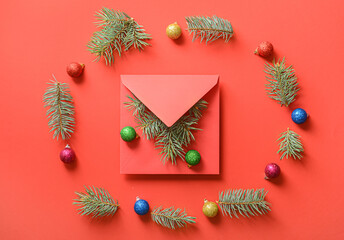 Envelope with Christmas decorations on color background