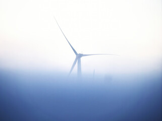 Tranquil scenery of a windmill covered in smog, misty wind turbine background