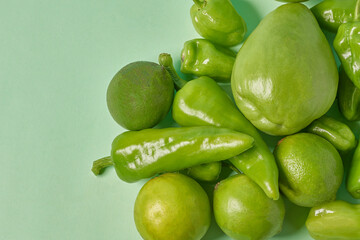 Green tusta chili, small Chayote and lemons on a soft green background. Vegetable fresh fruit and vegetable patterns