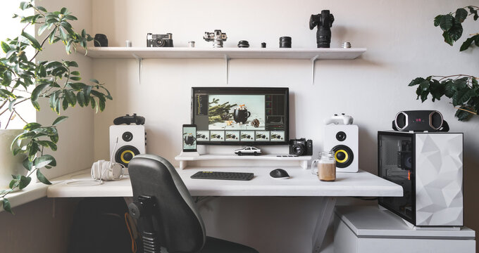 Modern male home office workplace with computer, smartphone, headphones and photo camera