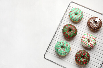 Grid with tasty Christmas donuts on white background